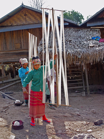 Akha girl, preparing the warp for her mother's loom